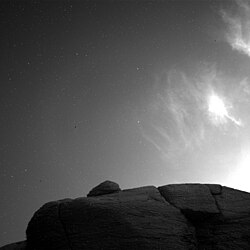 A composite black-and-white photograph showing cirrus clouds over the surface of Mars