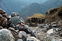 U.S. Army Soldiers with the 10th Mountain Division take cover during an ambush by enemy forces in Kunar province, Afghanistan, 2009