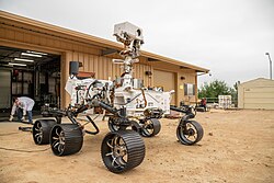 The full-scale twin engineering model of Perseverance, the OPTIMISM rover is used at the JPL Mars Yard for testing procedures and solving problems.[a]