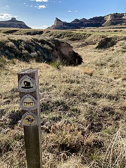 A photo of the former overland trails, with historic trails marker, through Mitchell Pass at Scotts Bluff National Monument.