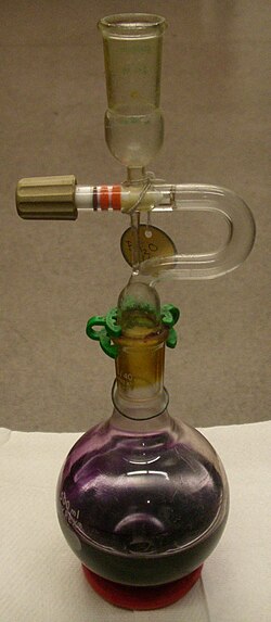 A solvent pot containing dibutyl ether solution of sodium benzophenone ketyl, which gives it its purple color.