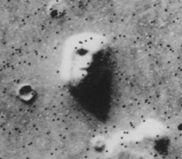 Cropped version of the original batch-processed image (#035A72) of the "Face on Mars". The black dots that give the image a speckled appearance are data errors (salt-and-pepper noise).[10]