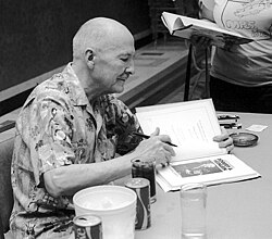 Heinlein autographs one of his works, 1976