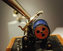 The blue cylinder appears in macro about the size of a toilet paper roll. The much larger handle has a minuscule needle poised above the cylinder.