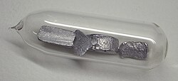 Very pure thallium pieces in a glass ampoule, stored under argon gas