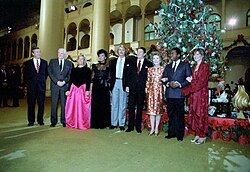 U.S. President Ronald Reagan and First Lady Nancy Reagan with a group at NBC's 1982 taping of its "Christmas in Washington" special in the Pension Building in Washington, D.C. Left to right: NBC News anchor Roger Mudd, CBS News reporter Eric Sevareid, Dinah Shore, actress Diahann Carroll, actor and musician John Schneider, President Ronald Reagan, First Lady Nancy Reagan, actor Ben Vereen, and entertainer Debby Boone.