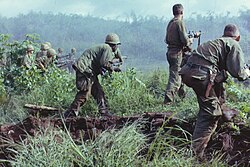 A U.S. Army infantry patrol moving up to assault the last North Vietnamese Army position at Dak To, South Vietnam during Operation Hawthorne