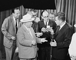 Nikita Khrushchev and Nixon speak as the press looks on at the Kitchen Debate on July 24, 1959; What's My Line? host John Charles Daly is on the far left.