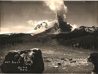 The "Great Explosion" eruption column of May 22, 1915, was seen as far as 150 mi (240 km) away. In the foreground is the Loomis Hot Rock, one of the many large boulders dislodged in the eruption that were too hot to touch for days after. (Photograph by B. F. Loomis; modern photo)