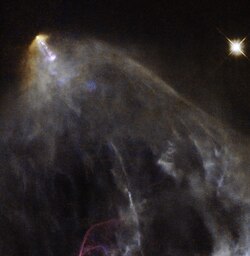 HH 151 is a bright jet of glowing material trailed by an intricate, orange-hued plume of gas and dust.[29]
