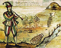 A medieval ink illustration of a person in striped red, white, yellow and green clothing playing a horn or pipe. The person appears to be driving or directing a sheep, which ambles ahead along a stream or brook. The background is a pastoral scene with hills and greenery.