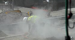Workers in a cloud of concrete dust containing respirable crystalline silica with no controls in place