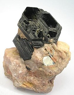 Perfect basal cleavage as seen in biotite (black), and good cleavage seen in the matrix (pink orthoclase).