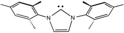 The N-heterocyclic carbene ligand called IMes is a bulky ligand by virtue of the pair of mesityl groups.