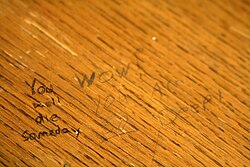 At the left, text written deeply onto the wood. At the right, text written more lightly.