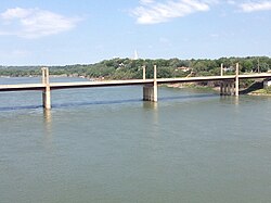 Yankton, as viewed from the Meridian Bridge with the Discovery Bridge crossing the Missouri River in the foreground, and the steeple of the Bishop Martin Marty Chapel in the background