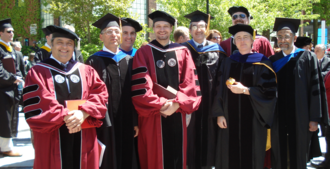 Professors and newly conferred doctors of philosophy posing at a Worcester Polytechnic Institute graduation