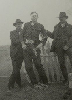 Cowboys hold up the corpse of outlaw John Shaw, who died in the Canyon Diablo shootout, 1905.