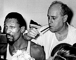 Red Auerbach, longtime coach of the Boston Celtics, lighting a cigar after his team won the 1966 NBA Finals