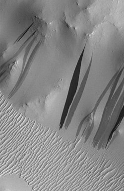 Dark slope streaks in Arabia Terra as seen by Mars Orbital Camera (MOC) on Mars Global Surveyor spacecraft. The darkest streaks are only about 10% darker than their surroundings. The greater apparent contrast in the image is due to contrast enhancement[1] Image is 1.65 km (1 mi) across. North is at bottom.