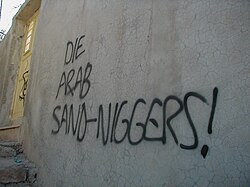 Graffiti reading "Die Arab Sand-Niggers!" reportedly sprayed by settlers on a house in Hebron[111]