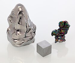 Melted tip of a hafnium consumable electrode used in an electron beam remelting furnace, a 1 cm cube, and an oxidized hafnium electron beam-remelted ingot (left to right)