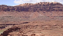 The Permian through Jurassic strata in the Colorado Plateau area of southeastern Utah demonstrate the principles of stratigraphy. These strata make up much of the famous prominent rock formations in widely spaced protected areas such as Capitol Reef National Park and Canyonlands National Park. From top to bottom: Rounded tan domes of the Navajo Sandstone, layered red Kayenta Formation, cliff-forming, vertically jointed, red Wingate Sandstone, slope-forming, purplish Chinle Formation, layered, lighter-red Moenkopi Formation, and white, layered Cutler Formation sandstone. Picture from Glen Canyon National Recreation Area, Utah.
