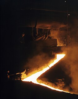 Slag run-off from one of the open hearth furnaces of a steel mill, Republic Steel, Youngstown, Ohio, November 1941. Slag is drawn off the furnace just before the molten steel is poured into ladles for ingotting.
