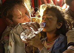 A young girl drinking bottled water