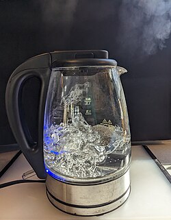 Boiling water creating steam in an electric kettle