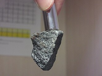 Magnetite is one of the very few minerals that is ferrimagnetic; it is attracted by a magnet as shown here