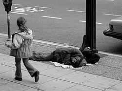 A man sleeps on the street.