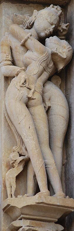 Tantric depiction of loving embrace at a temple relief of Khajuraho Group of Monuments, Madhya Pradesh, India – a UNESCO World Heritage Site