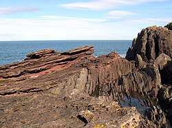 An eroded outcrop at Siccar Point showing sloping red sandstone above vertical greywacke was sketched by Sir James Hall in 1788. Location: 55°55′53″N 2°18′05″W﻿ / ﻿55.9315°N 2.3013°W﻿ / 55.9315; -2.3013﻿ (Hutton Unconformity, Jedburgh)