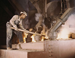 A worker tends an electric phosphate smelting furnace in Muscle Shoals, Alabama, 1942