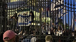 Demonstrators holding Israeli flags climbing Columbia's gates on Amsterdam Avenue and during the StandWithUs United for Israel march and rally, April 25.