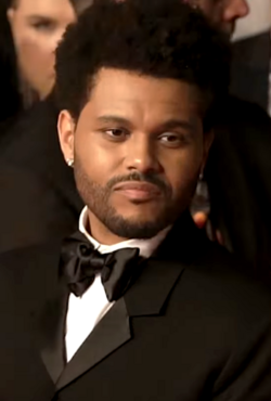 The Weeknd, in a tuxedo, slightly looks away from the camera.