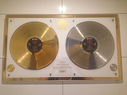 Gold and silver discs issued by EMI in 1982 for Greatest Hits (1981). With more than 25 million copies sold it is Queen's best selling album.