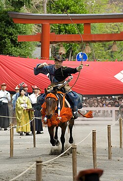 A rider performing yabusame as a sacred archery rite at Tsurugaoka Hachimangū, a shrine of the warrior deity Hachiman in Kamakura.