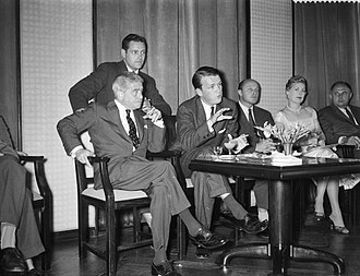 George Stevens Jr., associate producer of The Diary of Anne Frank, speaks at a July 1958 press conference in Amsterdam, with music director Alfred Newman on his left.