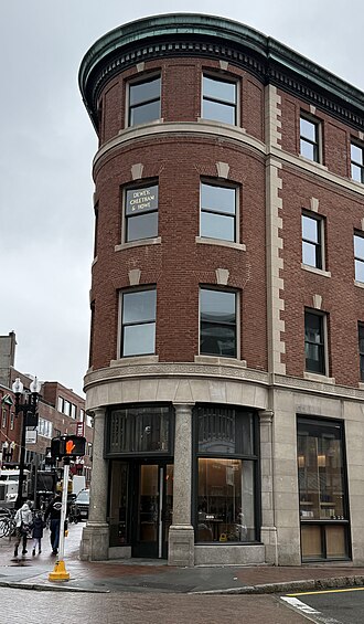 The name of the DC&H corporate offices is visible on the third-floor window above the corner of Brattle and JFK Streets, in Harvard Square, Cambridge, Massachusetts.