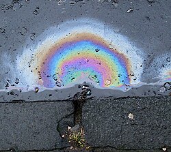 Diesel fuel is immiscible in water, the fuel instead remaining as a distinct layer. The bright rainbow pattern is the result of thin-film interference.