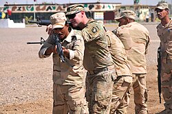 A trainer with Company A, 1st Battalion 502nd Infantry Regiment, Task Force Strike, 101st Airborne Division assisting Iraqi army ranger students during a room clearing drill at Camp Taji, Iraq on 18 July 2016
