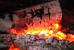 Firewood combusting into coal in a wood-burning stove, 2025