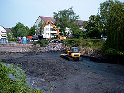 A drained pond, showing the layer of sludge on the bottom; its black colour is due to the presence of metal sulfides, the result of reactions with hydrogen sulfide produced by bacteria.