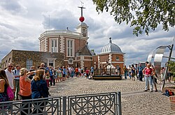 Tourists queuing to take pictures on the line of the historic prime meridian at the Royal Observatory, Greenwich