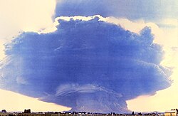 The ash cloud produced by the eruption, as seen from the village of Toledo, Washington, 35 mi (56 km) to the northwest of Mount St. Helens. The cloud was roughly 40 mi (64 km) wide and 15 mi (24 km; 79,000 ft) high.