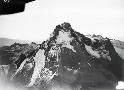 East-looking aerial view of Mt. Kenya, a glaciated high-altitude peak in tropical East Africa, May 1930. Glaciers form wherever persistent snowfall can accumulate into a mass large enough to compact into ice and flow under its own weight. Mt. Kenya's glaciers have been retreating since the 19th century,[25] and the summit no longer receives enough persistent snowfall to sustain them.[26]