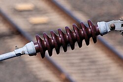 Ceramic insulator used on electrified railways. The ridged shape increases the surface distance along which electrical leakage could occur, thereby enhancing the insulator’s effectiveness, especially in wet or polluted conditions.