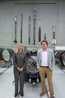 Peter Beck and Dava Newman posing in front of Rocket Lab's sounding rockets, 2016